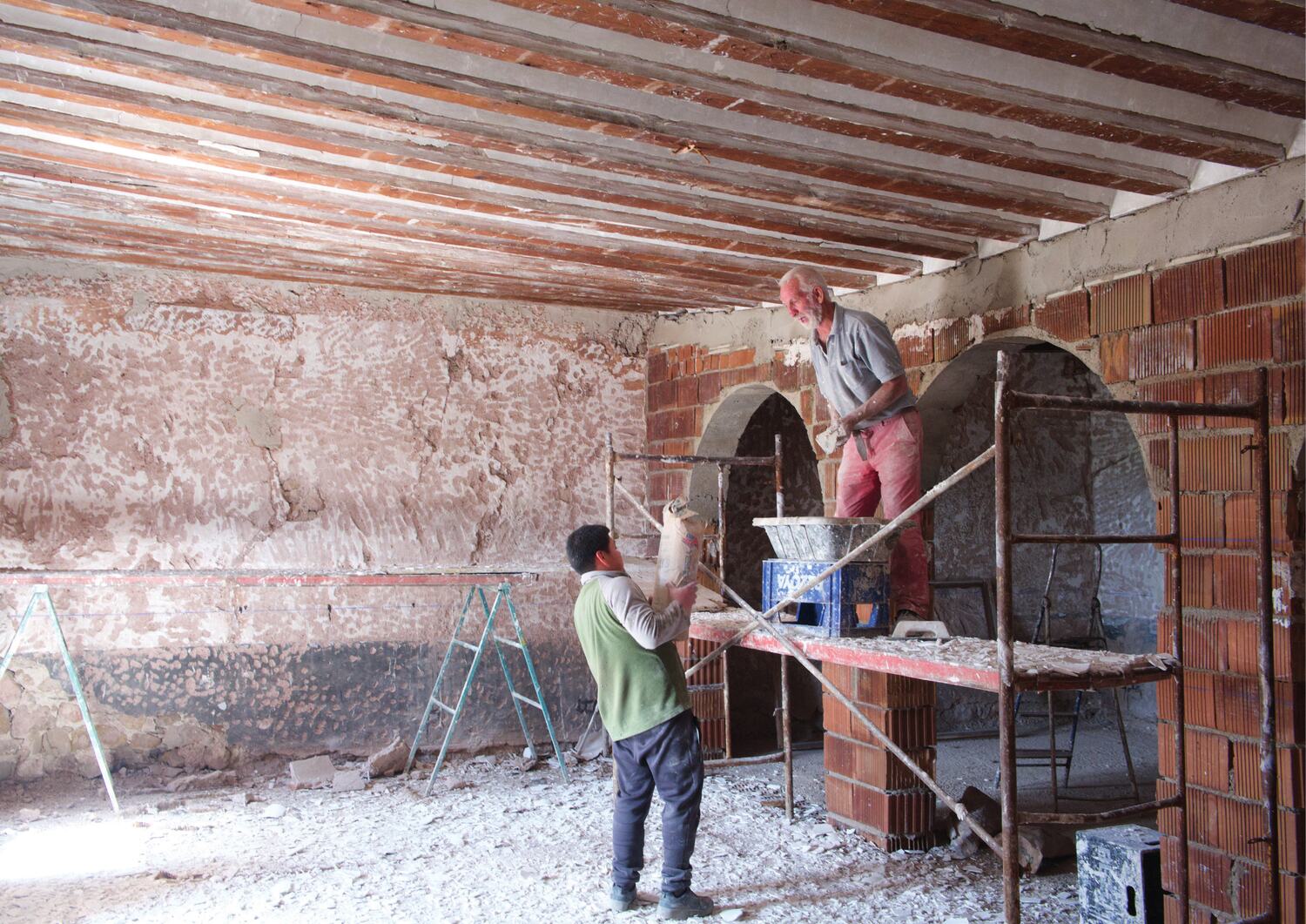 Two bricklayers building one of the arches